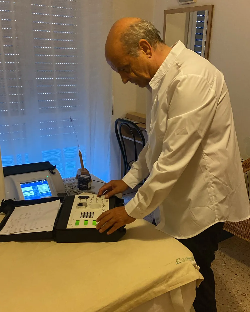 Pascal Possetti regola un apparecchio nella sua valigetta aperta